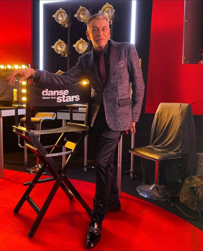 Muž v obleku, Patrick Dupond, pri stoličke s nápisom Danse avec le stars.